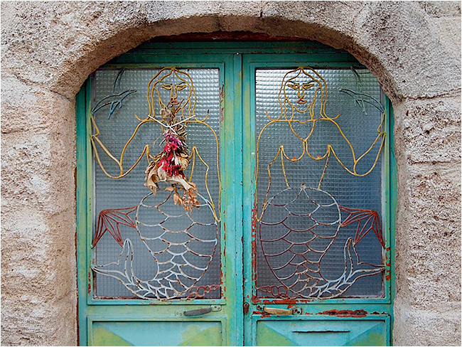 new window in an old Rhodes building. Mermaid motif with flowers. by John Laprairie ©