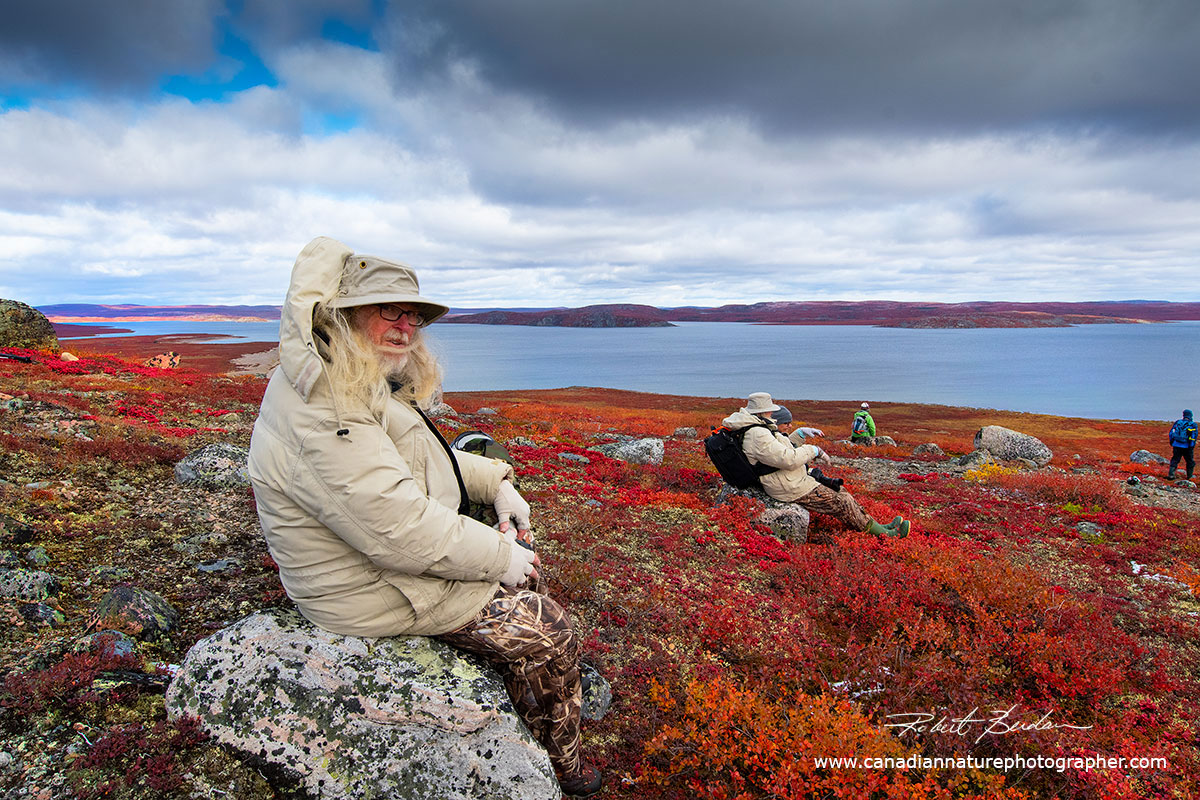 Elston Hill rests on a rock and surveys Point Lake, his wife Jackline is resting on the second rock by Robert Berdan ©