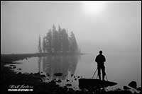 Black and white photo of photographer and tripod at sunrise Spirit Island, Jasper National Park, AB by Robert Berdan