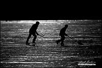 Black and white photo silhoutte of hockey players on Vermilion Lake, Banff National Park by Robert Berdan
