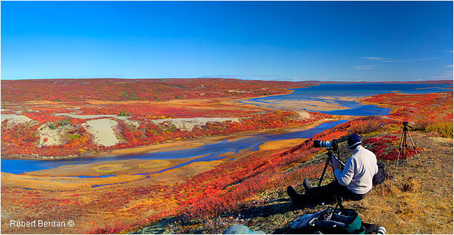Photographer sitting to use tripod overlooking the tundra ©